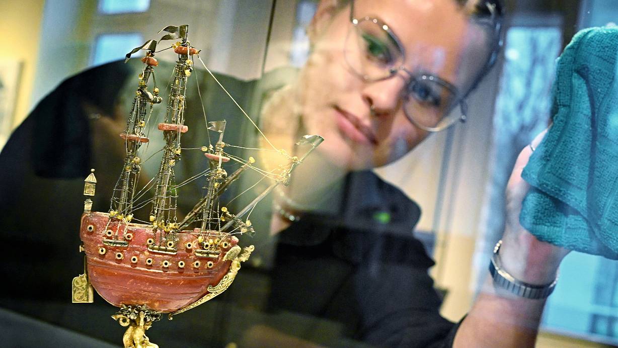 Museumspraktikantin Daria Rebriyev bewundert das einzigartige Bernsteinschiffchen in seiner beleuchteten Vitrine. | © Barbara Franke