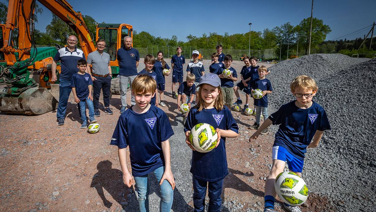 Halbzeit auf der Baustelle: Elias (7), Sophia (8), Elias (7, v.l.) und auch die anderen Mitglieder vom TuS Hoberge freuen sich, dass die alte Asche weg ist und sie auf ihrem Platz bald auf Kunstrasen kicken können. | © Sarah Jonek Fotografie