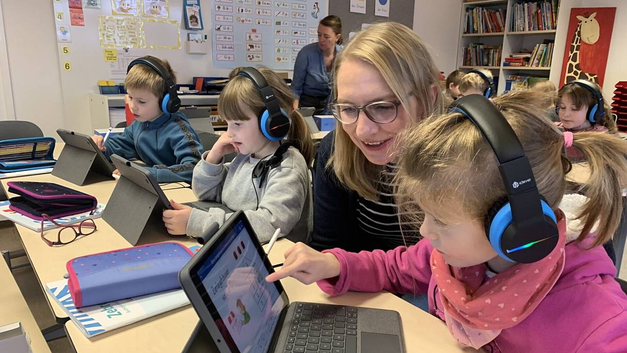 Mit dem iPad zu lernen, motiviert Lisa (vorne) und ihre Klassenkameraden. Dass die Kinder alle ein eigenes Gerät haben, mache das Arbeiten damit deutlich effizienter, sagt Lehrerin Gudrun Buschmeier (2.v.r.). | © Ivonne Michel