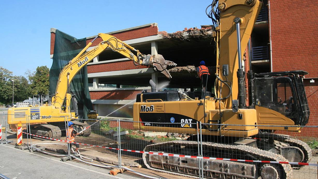 Um die Staubbildung zu verringern richtet ein Bauarbeiter einen Wasserstrahl auf die Abbruchstellen. | © Frank Hartmann