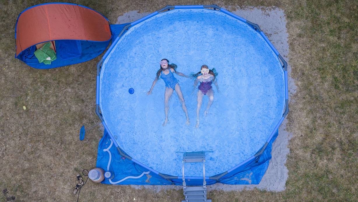 Zwei Kinder planschen in einem Pool im Garten ihres Elternhauses. | © picture alliance/dpa