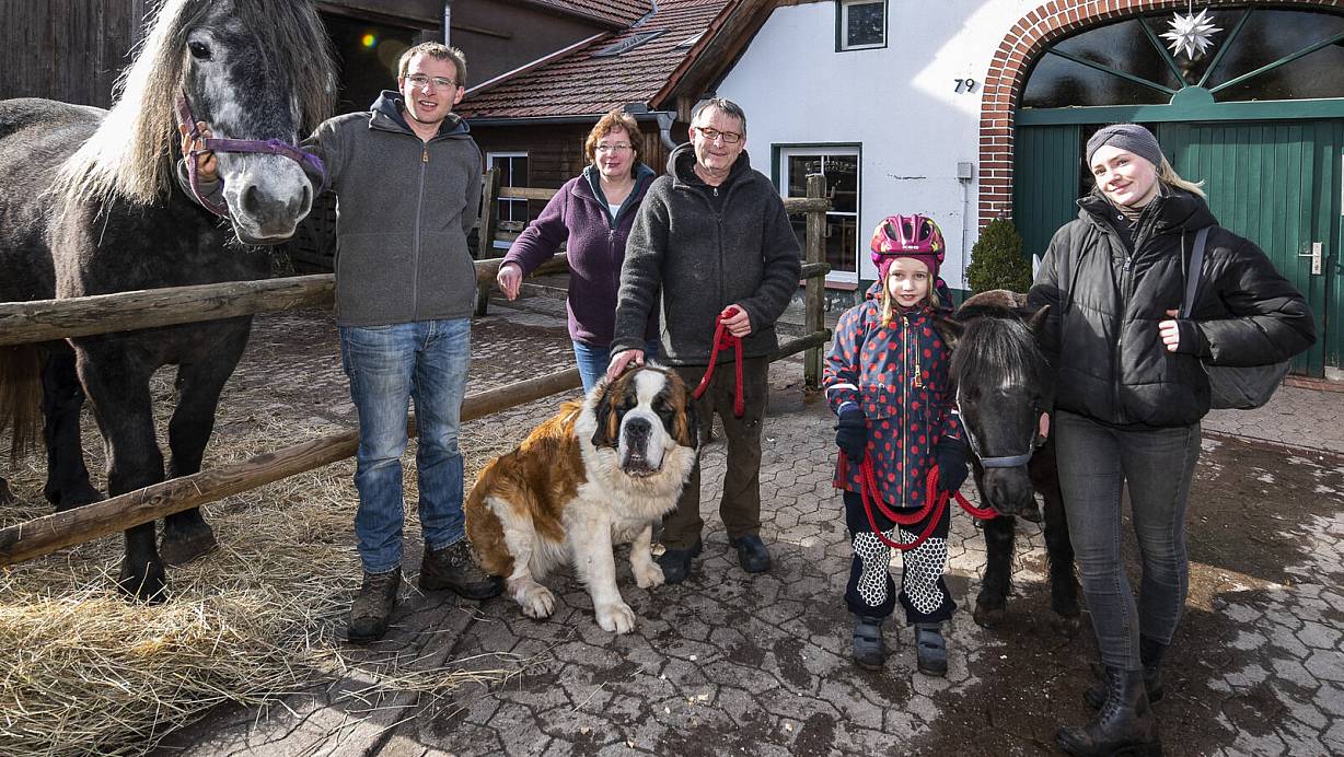 Zumindest endlich mal Sonnenschein: Jan, Elke und Ralf Wörmann (v. l.), Reitkind Lotta (6) und Reitlehrerin Kathy am Samstagnachmittag mit Pferden und Hofhund Bootsmann vor dem geschlossenen Hofcafé. | © Jörg Dieckmann - www.dieckmann-fotodesign.de