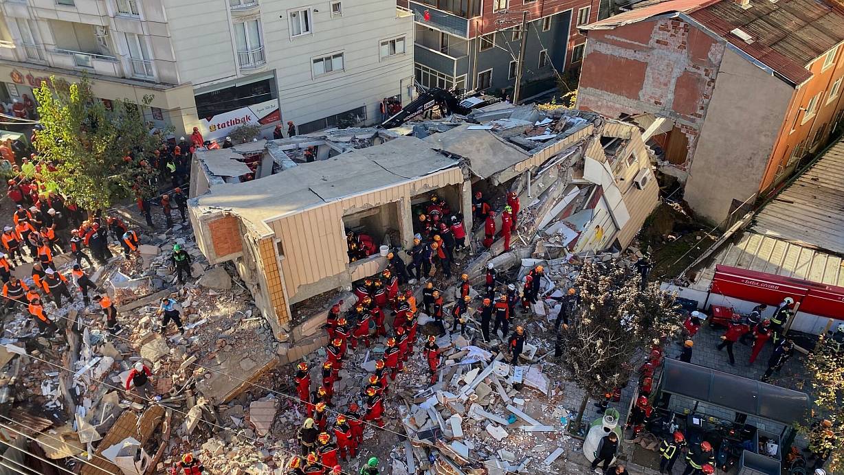 Feuerwehrleute und Rettungskräfte suchen nach dem Einsturz eines Wohngebäudes nach Verschütteten. | © Cihan Atik/IHA/AP/dpa