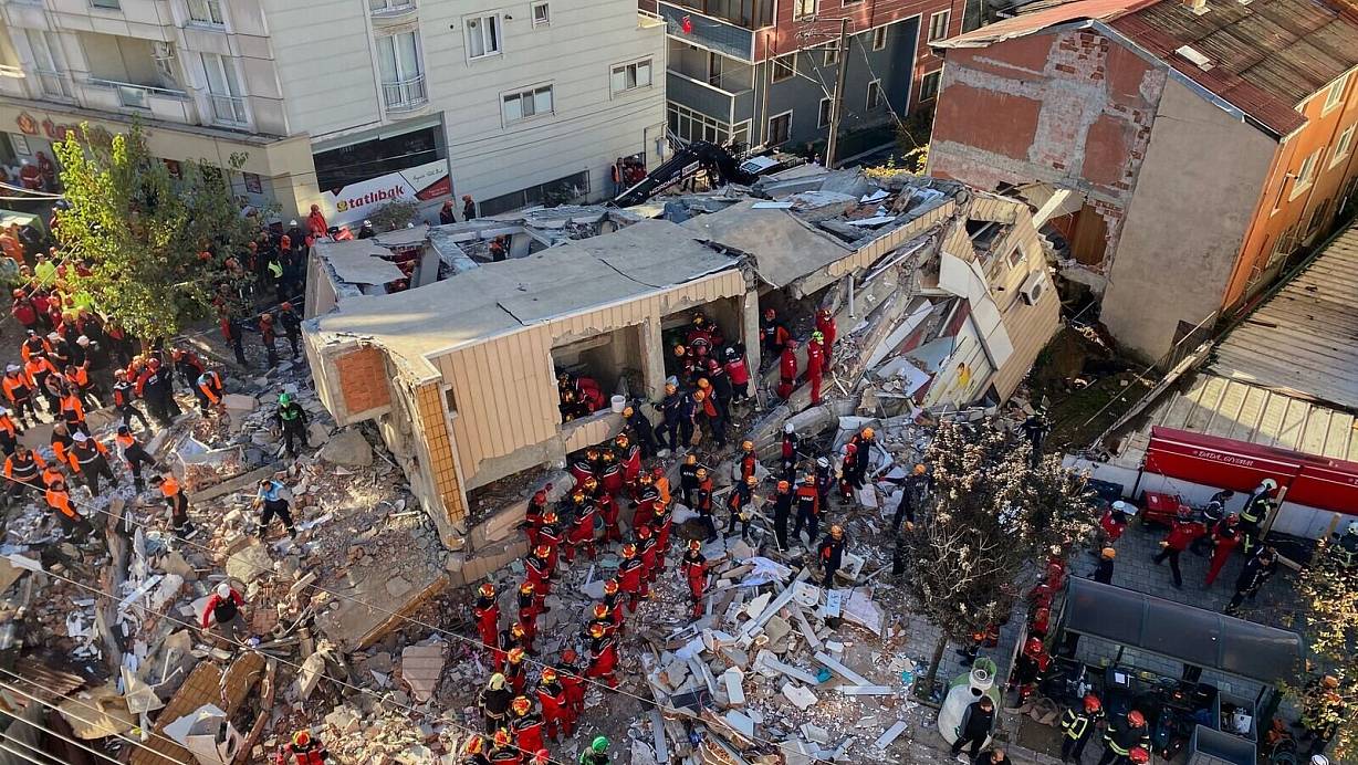 Feuerwehrleute und Rettungskräfte suchen nach dem Einsturz eines Wohngebäudes nach Verschütteten. | © Cihan Atik/IHA/AP/dpa