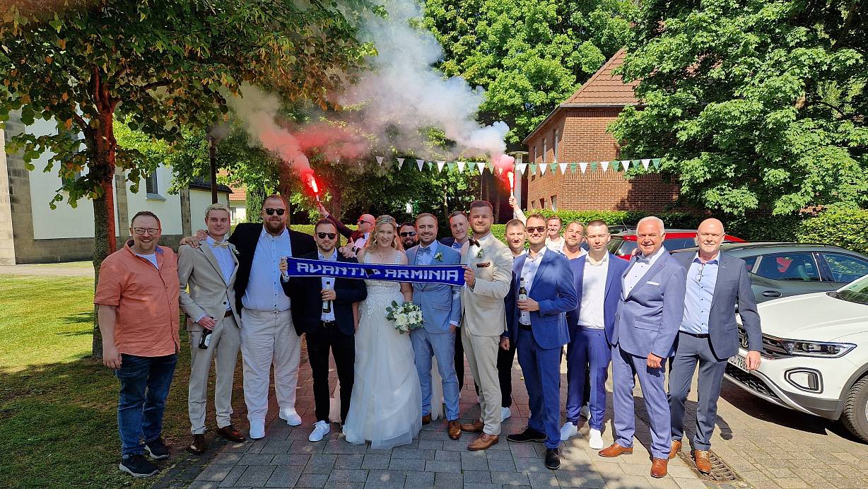Fußballverrückte Familie und Freunde stellen sich nach der Trauung von Kristin und René Prehn zum Foto auf – sie können nicht nur die frisch Vermählten feiern, sondern auch den ebenso frischen Aufstieg des DSC Arminia. | © Oliver Prehn