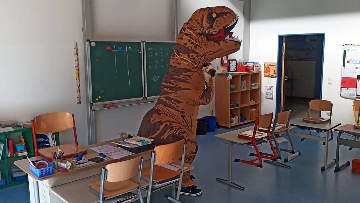 Ein Dinosaurier in der Grundschule Altenautal? Unter dem Kostüm versteckt sich Schulleiter Markus Kremer, der für die Jungen und Mädchen Videos auf Youtube einstellt. | © Markus Kremer