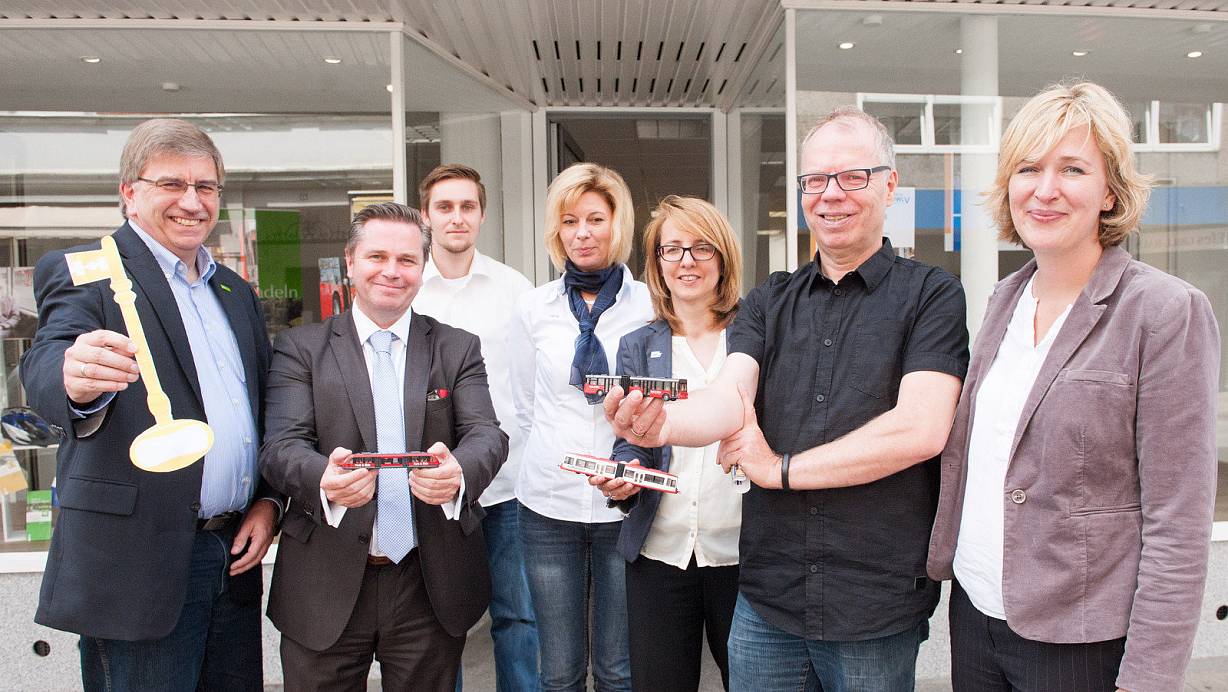 Der Schlüssel zu mehr Mobilität: Dieter Wulfmeyer (Stadtverkehr Herford), hält ihn. Bürgermeister Tim Kähler, Cornelia Christian (OWL Verkehr) und Achim Overath (MHV) halten Modelle von Bus, Bahn und Straßenbahn. Im Hintergrund sind die Mobilitätsberater Philipp Sasse und Anja Feldmann, rechts Karin Schnake. | © Ralf Bittner