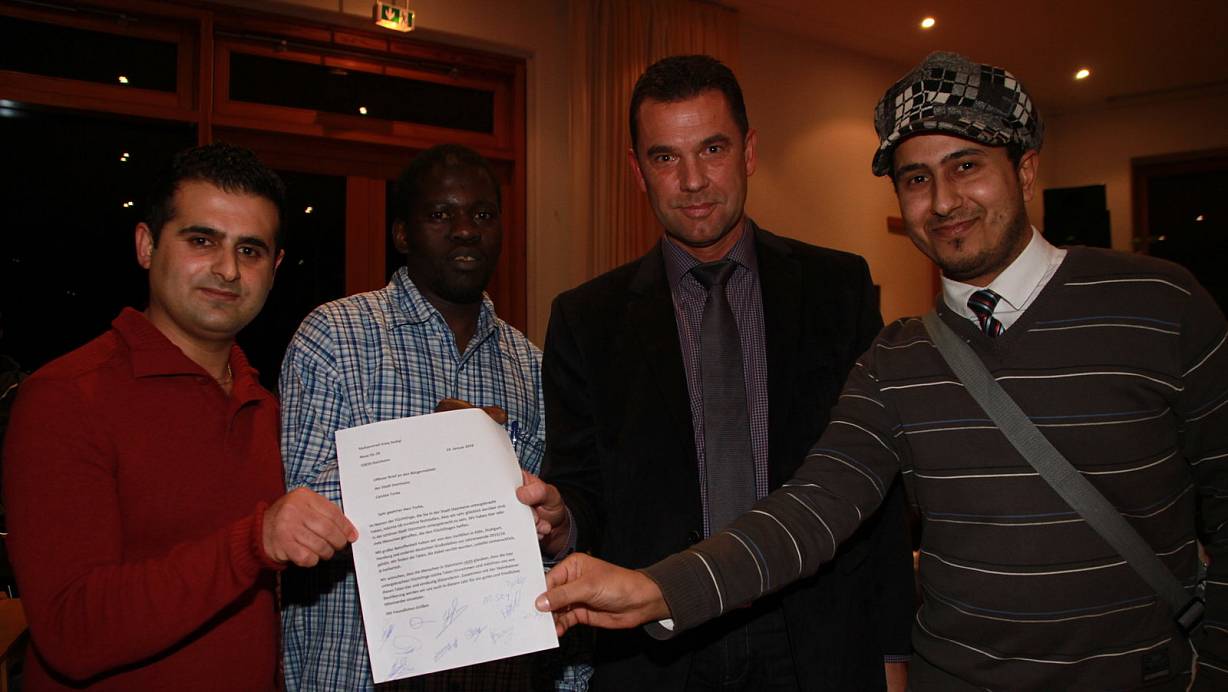 Als Zeichen: Mohammad Issag Sedigi (v. l.) aus Afghanistan, Mahamasou Sey aus Gambia und Mohammed Al Saedi (r.) aus dem Irak übergeben stellvertretend für alle Flüchtlinge in Steinheim einen Brief an Bürgermeister Carsten Torke. | © Madita Schellenberg