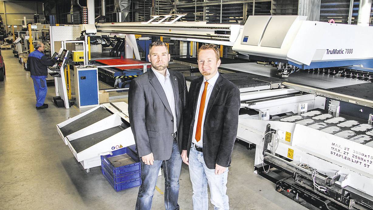 In der Produktionshalle: Die Geschäftsführer Alexander Wieneke (l.) und Tobias Wieneke an einer modernen Laserstanz-Maschine. Der Bau des Gebäudes in Herste hat nur vier Monate gedauert. | © David Schellenberg