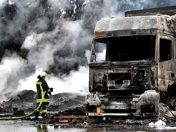 Die Feuerwehr hat bis zum Morgen das Feuer in der Palettenfabrik gelöscht. Inzwischen beginnen die ersten Aufräumarbeiten. Hier ist einer der ausgebrannten Lastwagen zu sehen. - © FOTO: TYLER LARKIN