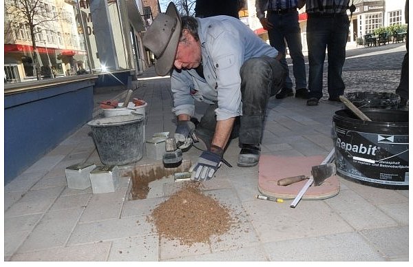 Der Künstler Gunter Demnig verlegt in der Marktstraße der Emmerstadt Stolpersteine, die an die jüdische Familie Herzfeld erinnern. Eingraviert sind die Namen, Geburts- und Todesdaten der ehemaligen Steinheimer Kaufleute. - © FOTO: MADITA PEINE