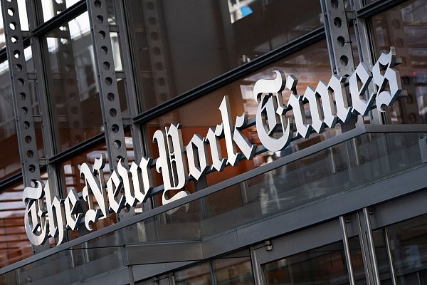 Der Schriftzug „The New York Times“ hängt über dem Eingang zum Gebäude. - © Mark Lennihan/AP/dpa
