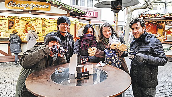 Am Glühweinstand: Seonkyemg Yu, Kyuhung Lee, Ai Suzuki, Melanie Wigger, Puppe Balthasar und Aron Leijendeckers tauschen sich über das Thema Weihnachten aus. - © Privat