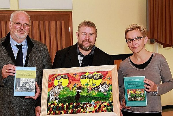 Hans-Walter Schmuhl (l.) und Ulrike Winkler zusammen mit dem Künstler Uwe Jauch (Mitte), der das Bild auf dem Buchcover gemalt hat. - © FOTO: ANKE MARHOLDT