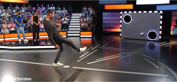 Mitch Kniat versenkt den Ball beim Torwandschießen. Er trifft einmal, seine Gegner Anna Elendt und Hassan Ali Aldemir (im Hintergrund) gehen leer aus. - © Screenshot NW