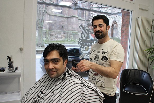 Mitarbeiter Saivan Aliismail schneidet Murat Dolu aus Bonenburg die Haare. Aliismail ist besonders auf orientalische Bartpflege spezialisiert. - © Anna-Lena Ryczek