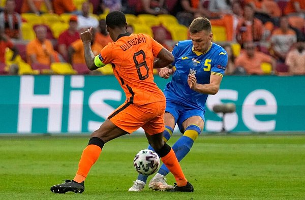 Der Niederländer Georginio Wijnaldum (l) im Zweikampf mit Sergej Sidortschuk aus der Ukraine. - © Peter Dejong/AP Pool/dpa