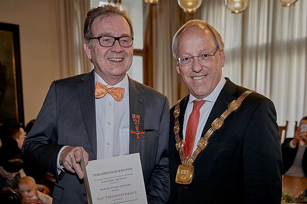 Langer Name, hohe Ehre: Der Bundesverdienstkreuz am Bande des Verdienstordens der Bundesrepublik Deutschland für Michael Eisenmeyer (l.) - überreicht von OB Pit Clausen. - © Foto: Christina Falke