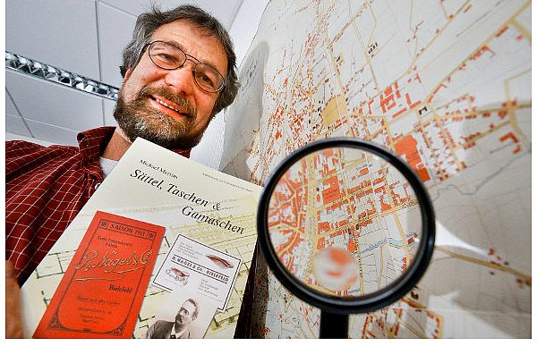 Michael Mertins mit dem historischen Stadtplan aus dem Jahr 1895, in dem die Fahrradfabrik der Firma Nagel & Co. von 1887 an der Turnerstraße 54 bis 58 eingezeichnet war. Das Gebäude wurde erst 1977 abgerissen. Die Firma Anker hatte den Backsteinbau übernommen. Nach der Pleite von 1976 stand das Gebäude leer und zog Obdachlose an, wie die Neue Westfälische am 6. Juli 1976 schrieb. - © FOTO: ANDREAS ZOBE