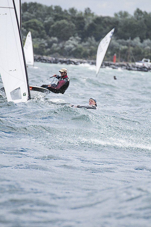 Rauhe See: Fabian Kirchhoff (r.) liegt bei einem der WM-Läufe quer über dem Wasser. Von seiner Jolle ist wegen der hohen Wellen nur das Segel (l.) zu sehen. Dahinter fährt ein Konkurrent. - © Foto: Privat||