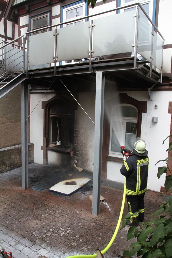 Löscharbeiten: Zur Sicherheit löschten die Feuerwehrleute nochmal Garten und Balkon ab. Zuvor hatte der Pfarrer bereits selbst die Flammen gelöscht. - © Dieter Scholz