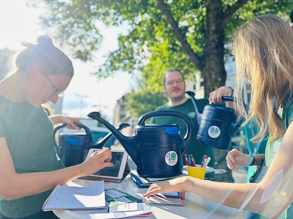 Das Team von "BaumBie wird noch an zwei Donnerstagen zum Abendmarkt mit der Gießkannen-Aktion am Stand weiter um Unterstützende und Interessierte für das Projekt werben. - © Stefan Becker
