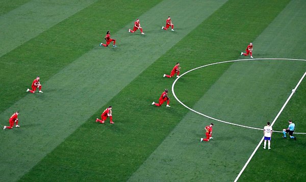 Die belgischen Spieler und der Schiedsrichter knieten vor dem Spiel gegen Russland. - © Dmitry Lovetsky/Reuters Pool/AP/dpa