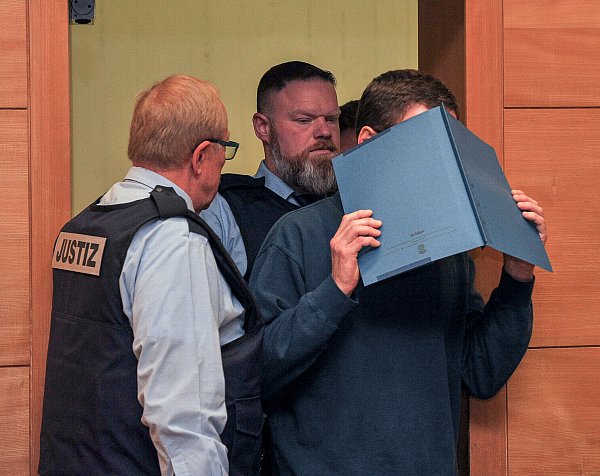 Beim Betreten des Gerichtssaals verbirgt der "Pausenbrotmörder" Klaus O. sein Gesicht hinter einer Akte. - © Christian Mathiesen