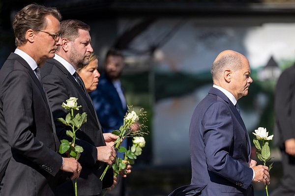 Hendrik Wüst (l-r, CDU), Ministerpräsident von Nordrhein-Westfalen, Tim Kurzbach (SPD), Bürgermeister von Solingen, Mona Neubaur (Grüne), stellvertretende Ministerpräsidentin von Nordrhein-Westfalen, und Bundeskanzler Olaf Scholz (SPD) legen weiße Rosen an einer Kirche in der Nähe des Tatorts ab. - © Thomas Banneyer