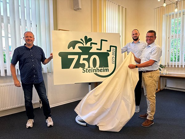 Anlässlich der 750. Jubiläumsfeier enthüllen Markus Waldhoff (v.l.), Alexander Rauer und Bürgermeister Carsten Torke das neue Logo. - © Sevim Hangül
