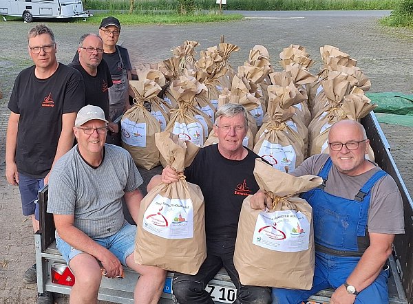 Andreas Heinemann, Heinz-Josef Heinemann, Matthias Heinemann sowie Hermann Bergmann, Jürgen Geldmacher und Burkhard Freff mit einer ganzen Ladung voll Holzkohlesäcke. - © Köhlerfreunde