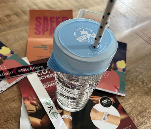 Der Inhalt eines „Safe Bags“: Ein Überzieher für Gläser, davor das weiße Test-Armband und allerlei Infomaterial. - © Kreis Paderborn
