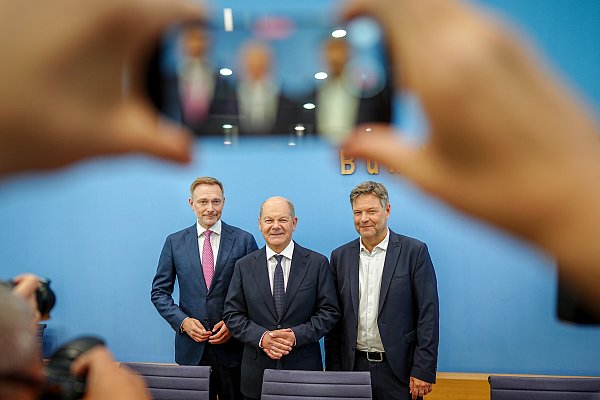 Bundeskanzler Olaf Scholz (SPD, m), Wirtschaftsminister Robert Habeck (Bündnis 90/Die Grünen, r), und Finanzminister Christian Lindner (FDP) nennen Details zum Haushaltsplan 2025. - © Kay Nietfeld/dpa