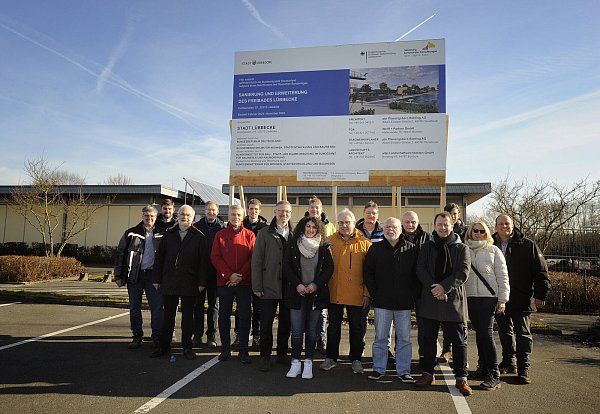 Mitglieder des Arbeitskreises Bäder, der WBL-Gesellschafterversammlung und Vertreter der beteiligten Planer und Bauunternehmen vor dem Baustellenschild, das die Sanierung des Freibads verkündet. - © Stadt Lübbecke