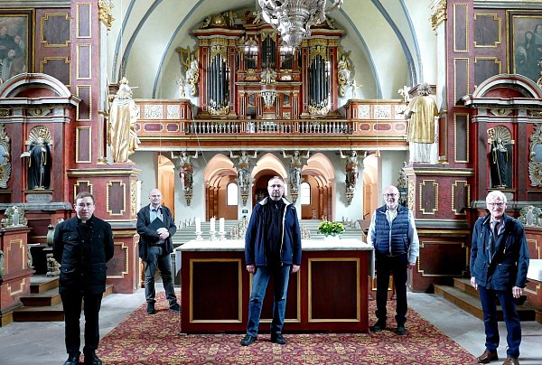 Dekanatskirchenmusiker Jörg Kraemer (Mitte) lässt die Orgel bei der Weihe am 12. Juni erklingen. Pfarrdechant Hans-Bernd Krismanek (v. l.), Architekt Albert Henne, Fördervereins-Vorsitzender Hermann Doninger (2. v. r.) und Josef Kowalski (Vorsitzender Kirchenvorstand) sind erfreut darüber, dass das kostbare Instrument wieder zurück ist. - © Gemeinde