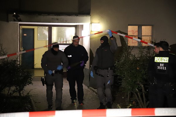 Beamte tragen einen als gefährlich eingestuften Gegenstand, der einer kleineren Granate ähnelt, aus dem Wohnhaus. - © Paul Zinken