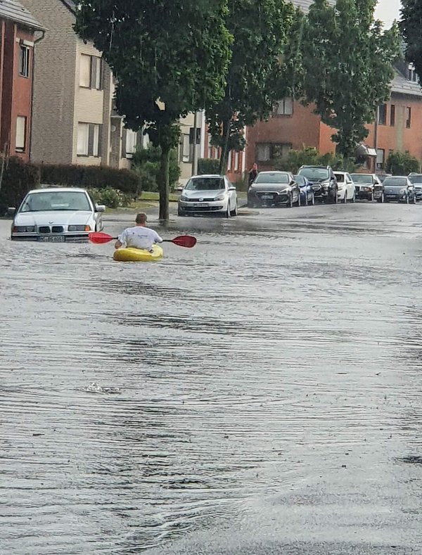 Mönchengladbch: Ein Mann fährt mit einem Kayak durch eine überflutete Straße. - © picture alliance/dpa/Einsatzreporter Niederrhein