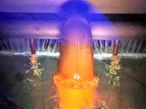 Durch ein Bullauge ist ein Blick in einen Wasserbehälter im Hauptwasserwerk der Stadtwerke Bielefeld möglich. Stetig rieselt aus Öffnungen der Zulieferleitungen hinein. - © Susanne Lahr