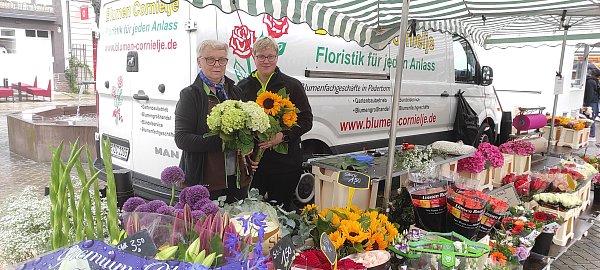 Gudrun Milleg (l.) und Andrea Milleg verkaufen auf dem Wochenmarkt in Höxter frische Blumen und gute Laune. - © Svenja Ludwig