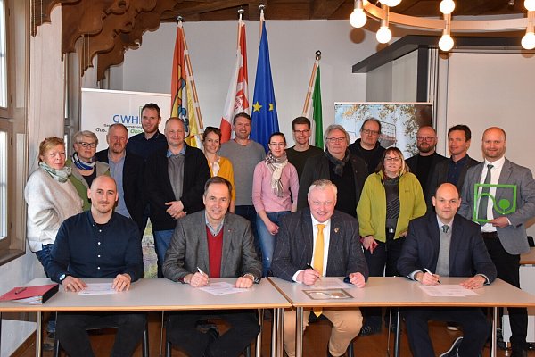 Jan Sommer (vorne v.l.), Helmut Rüskamp, Daniel Hartmann und Christoph Lau mit den beteiligten Gartenlandschaftsbau-Unternehmern bei der Vertragsunterzeichnung im Höxteraner Rathaus. - © Manuela Puls