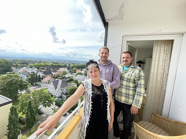 Svitlana (v.l.), Antolii und Volodymyr Fomenko genießen von ihrem Balkon aus den Ausblick auf die Stadt Herford. Auch nachts, wenn die Lichter der Stadt leuchten, liebt es Svitlana Fomenko, auf ihrem Balkon zu sein. - © Natalie Gottwald