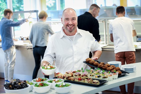 Chefkoch Meikel Haare (49) hält in seiner rechten Hand einen Salat, in der linken ein Tablett mit Muffins. Im Werksrestaurant von Dr. Wolff haben Mitarbeitende die Qual der Wahl. - © Sarah Jonek
