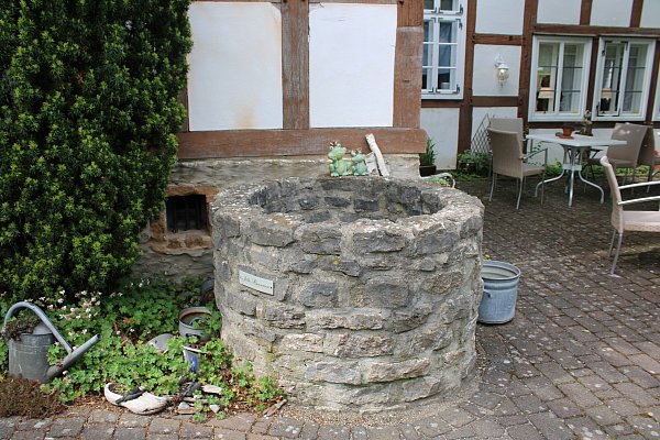 Gäste des Bauernhauscafés Jöllequelle können im Sommer neben dem historischen Brunnen sitzen. - © Sylvia Tetmeyer
