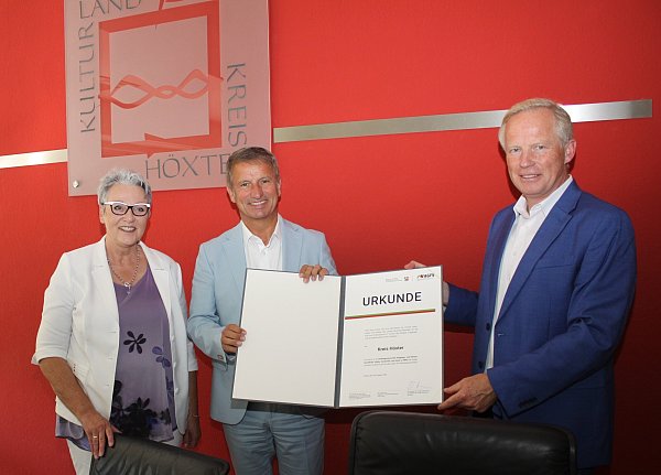 Christine Fuchs (Geschäftsführerin AGFS, v. l.), Landrat Michael Stickeln und Udo Sieverding (Abteilungsleiter Mobilität der Zukunft, Radverkehr, ÖPNV im Ministerium für Umwelt, Naturschutz und Verkehr des Landes Nordrhein-Westfalen) präsentieren die Urkunde. - © Kreis Höxter