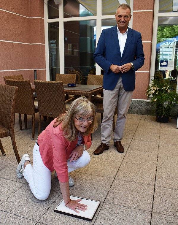 Geste der Wertschätzung: Zum Abschied hatte Bürgermeister Burkhard Deppe eine Überraschung für Christiane Seemer. Auf dem provisorischen „Driburg Thermen Boulevard“ sollte sie ihren Handabdruck hinterlassen, wie die Stars in Hollywood. Foto: Stadt - © Stadt Bad Driburg