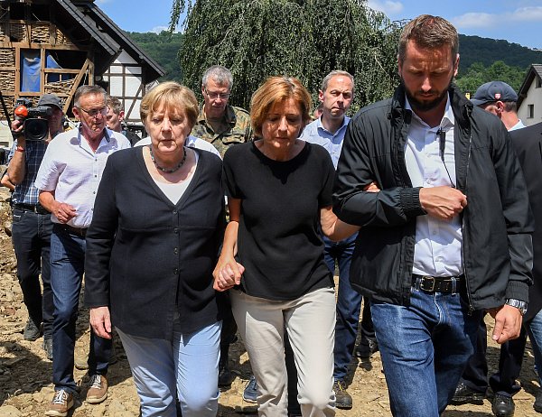 18. Juli 2021: Die damalige Bundeskanzlerin Angela Merkel (l.) und Ministerpräsidentin Malu Dreyer (Mitte), gehen durch das vom Hochwasser verwüstete Dorf Schuld in der Nähe von Bad Neuenahr-Ahrweiler. - © Christof Stache/POOL AFP/dpa
