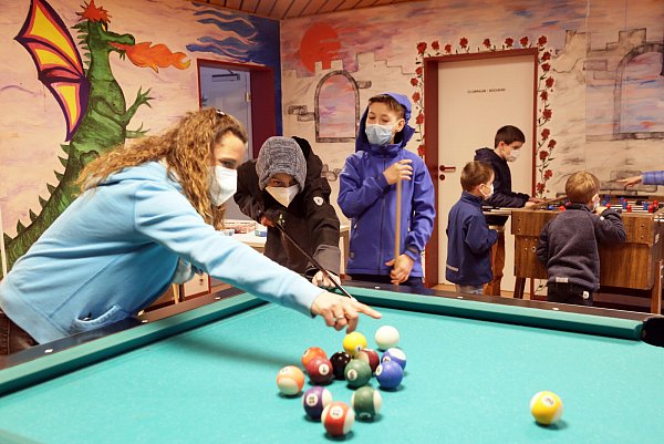 Die pädagogische Leiterin Susanne Grenz zeigt Eugen und Serge wie Billard gespielt wird. - © Kurt Blaschke