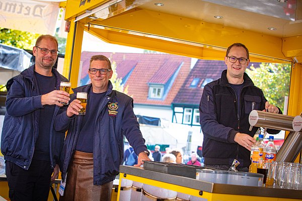 Robin Wasyliw (v.l.), Sven Rinke und Steve Kuhlmann von der Freiwilligen Feuerwehr zapfen das Bier. - © Mueller