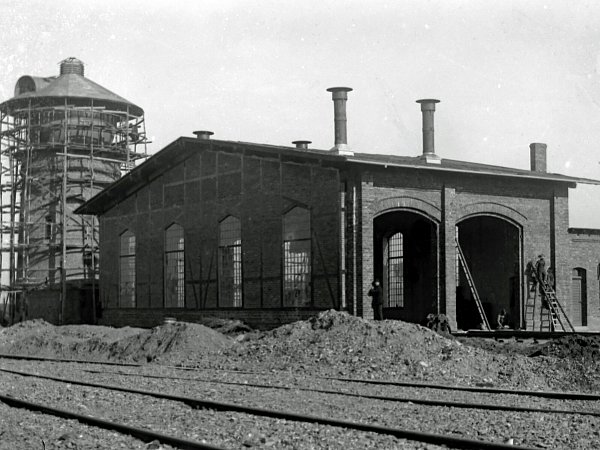 Um 1900 waren die ersten beiden Stände des Lokschuppens weitgehend fertiggestellt. Später wurden weitere sechs Stände angebaut und aus der Lokstation wurde das Bahnbetriebswerk Rahden. Die beiden ältesten Stände nutzt heute die Museumsbahn. - © Stadtarchiv Rahden / Sammlung Tielbürger