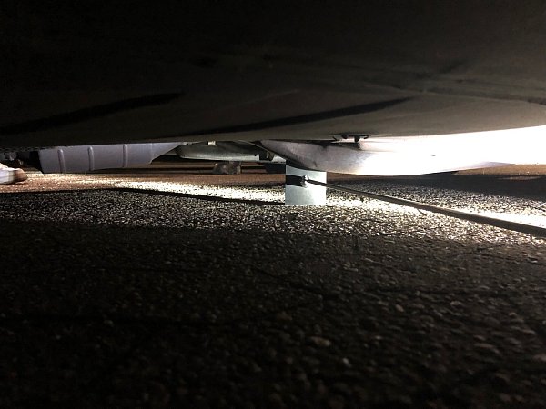 Mit einer passenden Metallplatte messen die Beamten die Bodenfreiheit der Fahrzeuge. - © Polizei Bielefeld